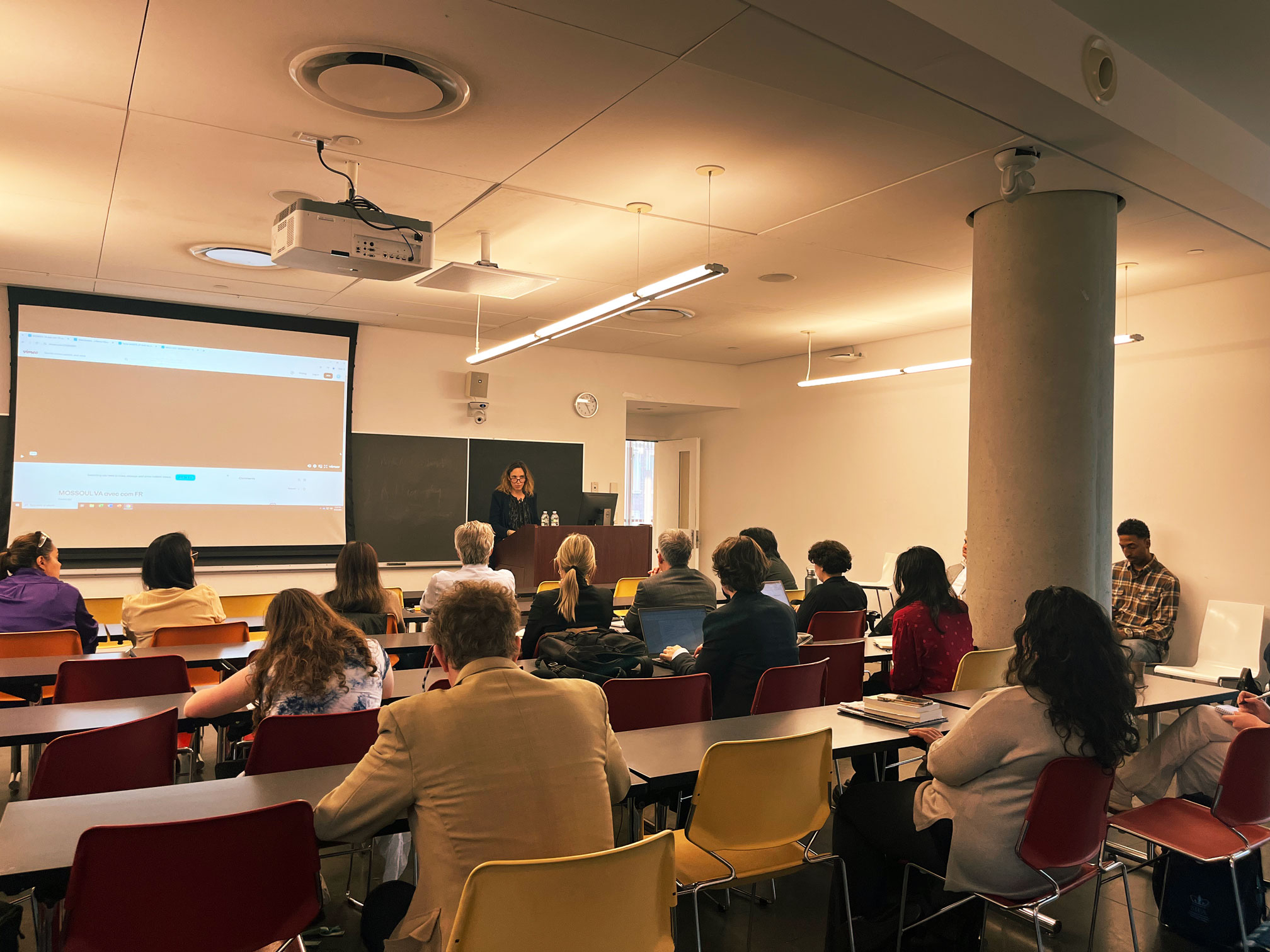 Classroom with woman standing in front of screen
